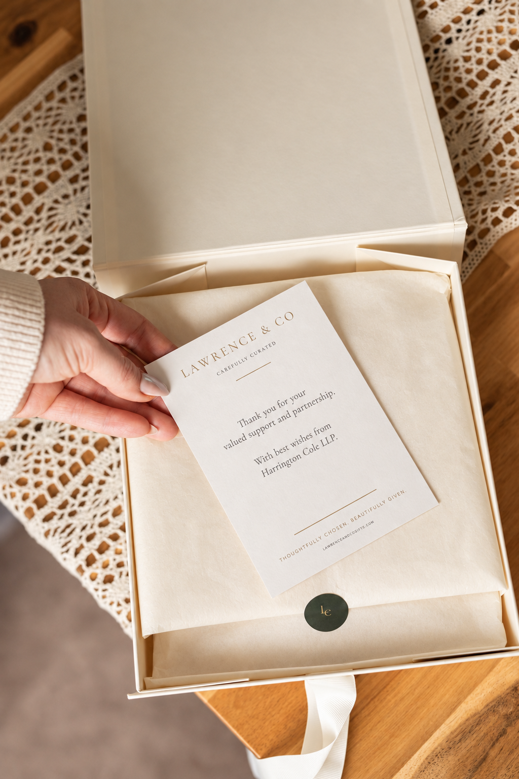 A personalised thank-you card resting on an open Lawrence & Co. gift box